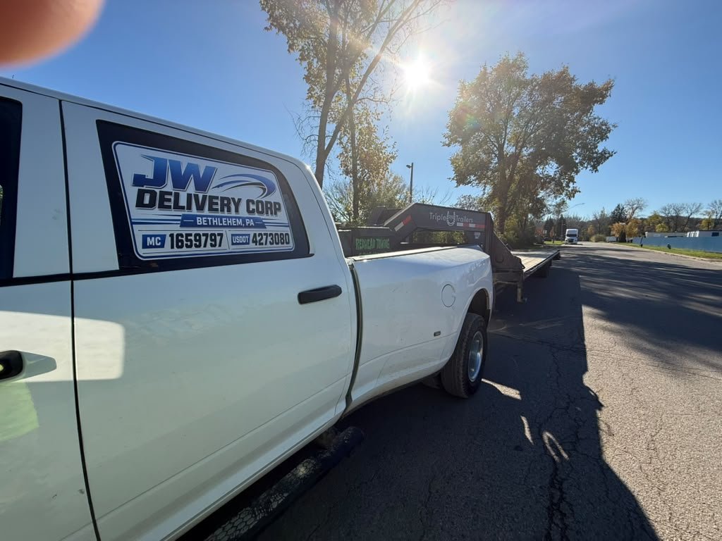 Pickup blanca de JW Delivery Corp estacionada junto a la carretera